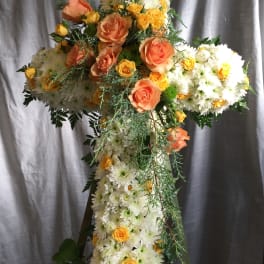 Cross-shaped floral arrangement with white daisies and peach roses