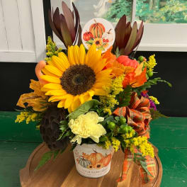 Fall floral arrangement with a sunflower in a pumpkin-themed pot