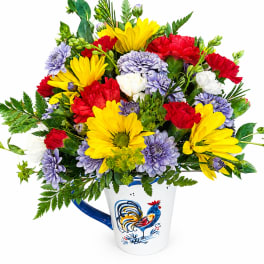 Colorful bouquet of daisies and carnations in a white mug with a rooster design
