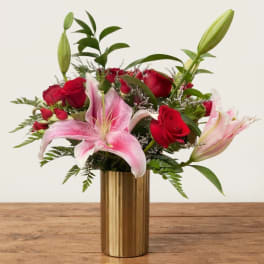 Pink lilies and red roses in a gold vase