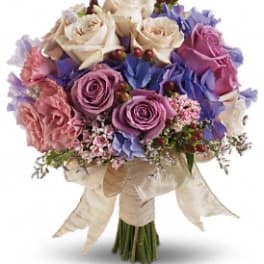 Hand-tied bouquet of pink, lavender, and cream roses with ribbon wrap