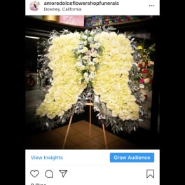 Large white floral funeral spray on an easel