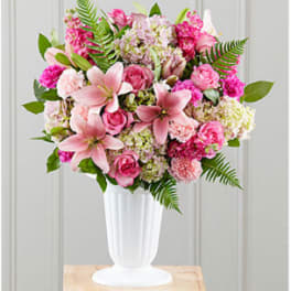 Pink mixed flower arrangement in a white vase