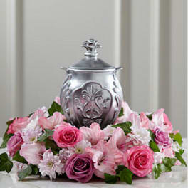 Pink and white floral arrangement around a silver urn