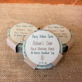 Three bars of handmade soap with paper labels on burlap