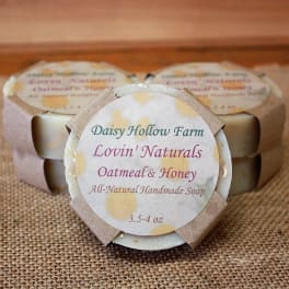Three wrapped bars of oatmeal and honey soap on burlap