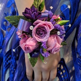 Purple and pink wrist corsage with roses and ribbon