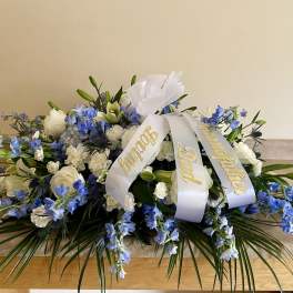 White and blue funeral spray with a memorial ribbon