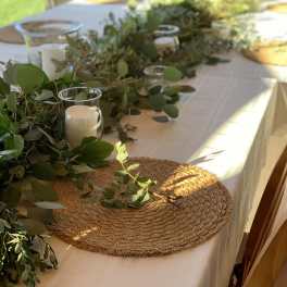 Greenery garland with glass candle holders on a white table