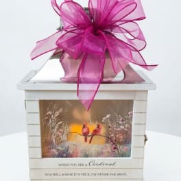 Decorative white lantern with a large pink bow and cardinal artwork