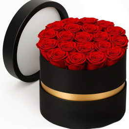Red roses arranged in a round black hat box with a gold band