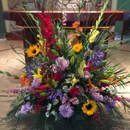 Large colorful floral arrangement with sunflowers, roses, and lilies