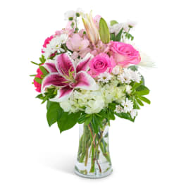 Pink roses and lilies in a clear glass vase