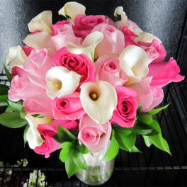 Pink roses and white calla lilies in a clear glass vase