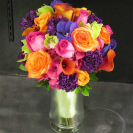 Bright mixed bouquet of roses and calla lilies in a glass vase