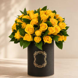 Yellow roses arranged in a black cylindrical box