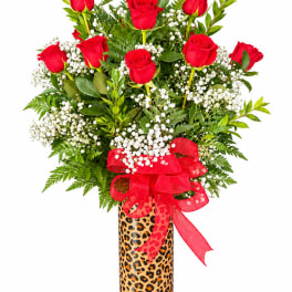 Red roses in a leopard-print vase with a red ribbon