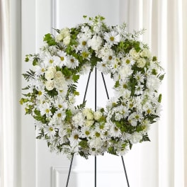 White floral wreath on a black stand