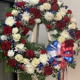 Large floral wreath with red, white, and blue flowers on an easel