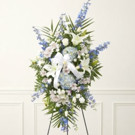 Tall blue and white floral standing spray with a white ribbon
