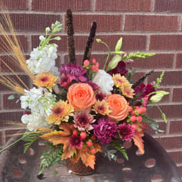 Mixed bouquet in a copper vase with orange roses and white blooms
