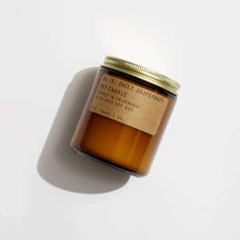 Amber jar candle with a gold lid and paper label