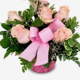 Pink roses in a pink vase with a large pink ribbon