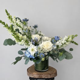 White roses and blue flowers in a green vase
