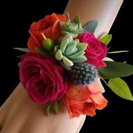 Wrist corsage with pink and orange roses and a small succulent