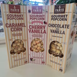 Three boxes of Faris gourmet popcorn in caramel, cherry vanilla, and chocolate vanilla
