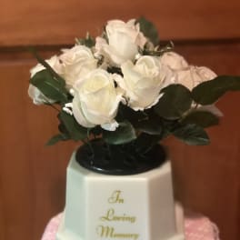 White roses in a memorial vase with "In Loving Memory" text