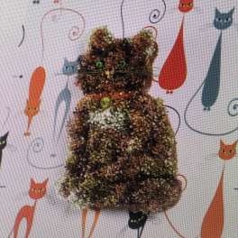 Cat-shaped glitter decoration with green eyes on a patterned background