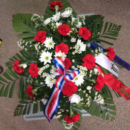 Red and white floral wreath with ribbon accents