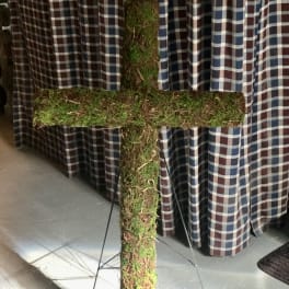 Moss-covered cross on a stand