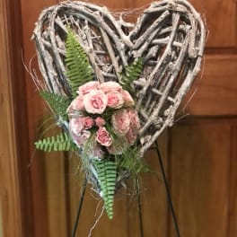 Heart-shaped twig wreath with pink roses and fern accents