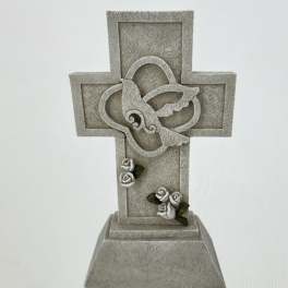 Decorative stone cross with small white roses and green leaves