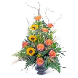 Tall floral arrangement with sunflowers and orange roses in a dark vase
