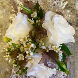 White floral bouquet with brown ribbon and decorative packaging