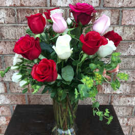 Bouquet of red, pink, and white roses in a clear glass vase