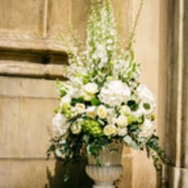 Tall white floral arrangement in a pedestal urn