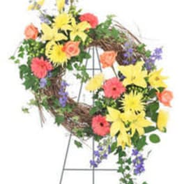 Floral wreath on an easel with yellow, pink, orange, and purple flowers