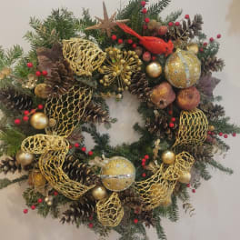 Christmas wreath with pinecones, gold ornaments, and a red cardinal
