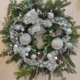 Christmas wreath with silver ornaments, pinecones, and a sheer ribbon