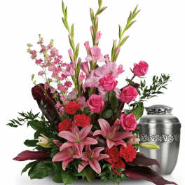 Pink and red floral arrangement with a silver urn