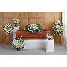 White funeral flowers arranged around a casket
