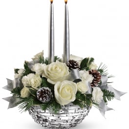 White roses and carnations in a silver basket with two taper candles