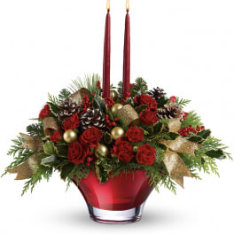Holiday arrangement with red roses, candles, and pinecones in a red vase