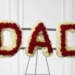 Floral tribute spelling DAD in red and white flowers on a stand