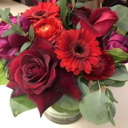 Bouquet of red roses and gerbera daisies in a glass vase