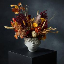 Autumn floral arrangement in a sculpted face vase